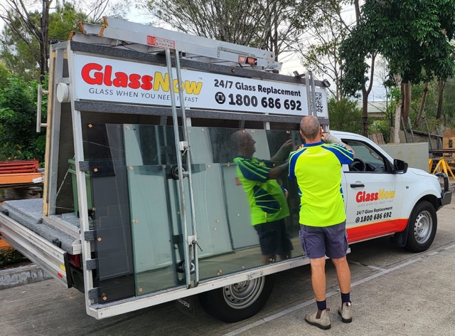 Glazier unloading shower glass panels from a GlassNow ute in a Brisbane